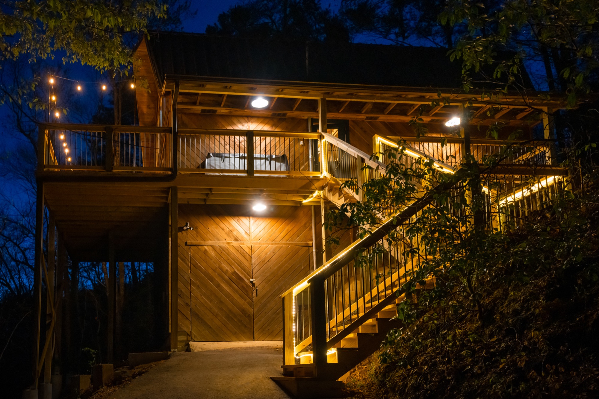 Rustic Retreat's exterior deck stairs lit at night